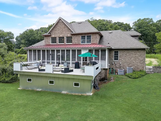 an aerial view of residential house with outdoor space and trees