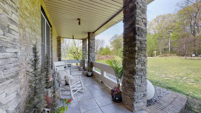 a view of a porch with chairs and backyard