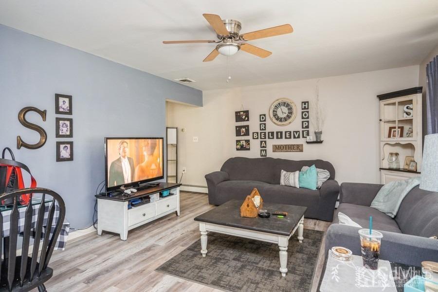 121 Winthrop Road Edison, NJ 08817 - Photo 9 of 16 a living room with furniture a flat screen tv and a window