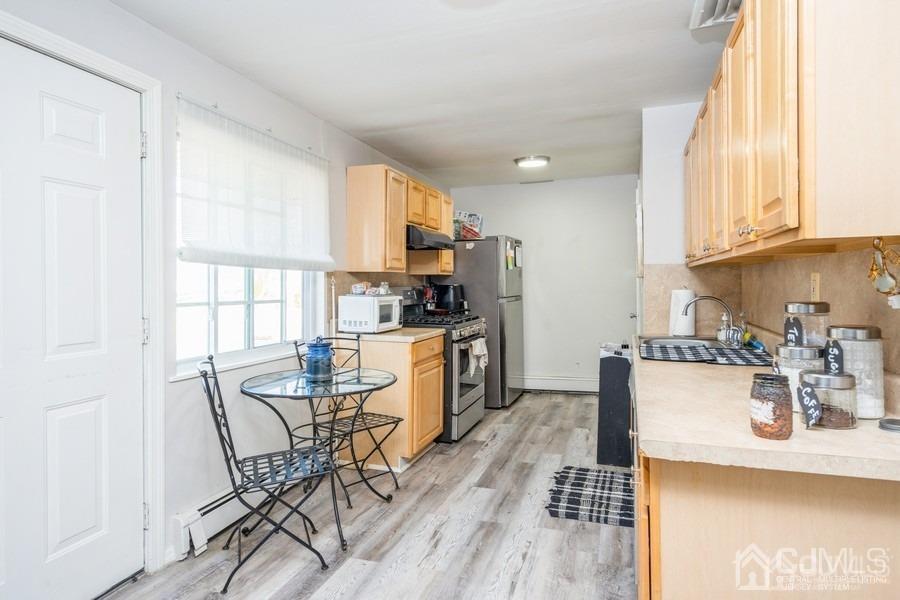 121 Winthrop Road Edison, NJ 08817 - Photo 10 of 16 a kitchen with a table chairs microwave and cabinets