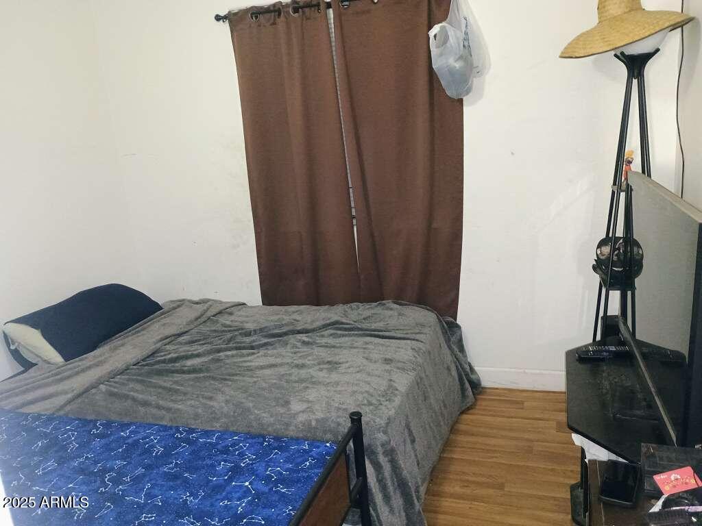 1748 West Sherman Street Phoenix, AZ 85007 - Photo 11 of 15 a bed sitting in a bedroom next to a window