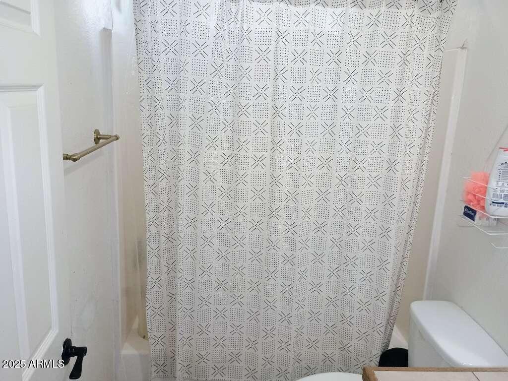 1748 West Sherman Street Phoenix, AZ 85007 - Photo 15 of 15 a bathroom with a toilet and a shower curtain