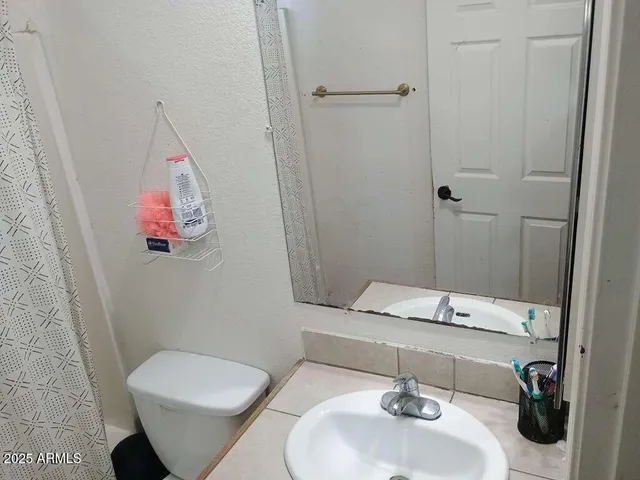 a bathroom with a sink and mirror with toilet