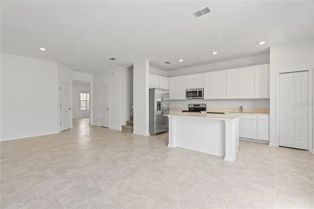 a view of kitchen refrigerator and cabinets