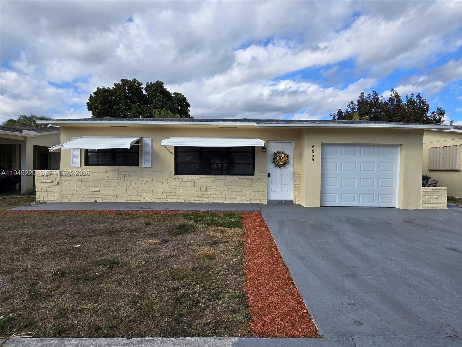 6855 Northwest 9th Street Margate, FL 33063 - Photo 2 of 21 a front view of a house with a yard and garage