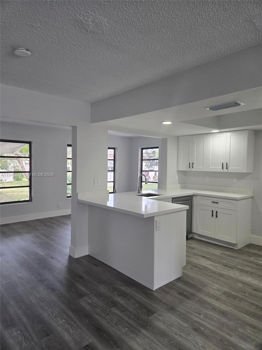 6855 Northwest 9th Street Margate, FL 33063 - Photo 4 of 21 a kitchen with wooden floors and white cabinets