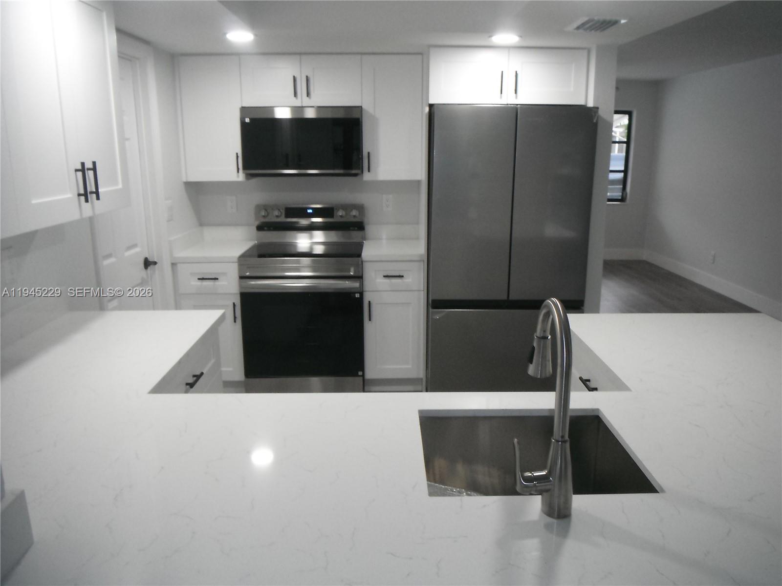 6855 Northwest 9th Street Margate, FL 33063 - Photo 6 of 21 a kitchen with stainless steel appliances a refrigerator a stove a microwave and cabinets
