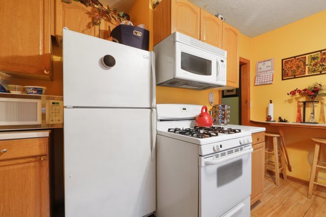 12504 Maple Avenue Blue Island, IL 60406 - Photo 12 of 25 a kitchen with stainless steel appliances granite countertop a stove a refrigerator and a microwave