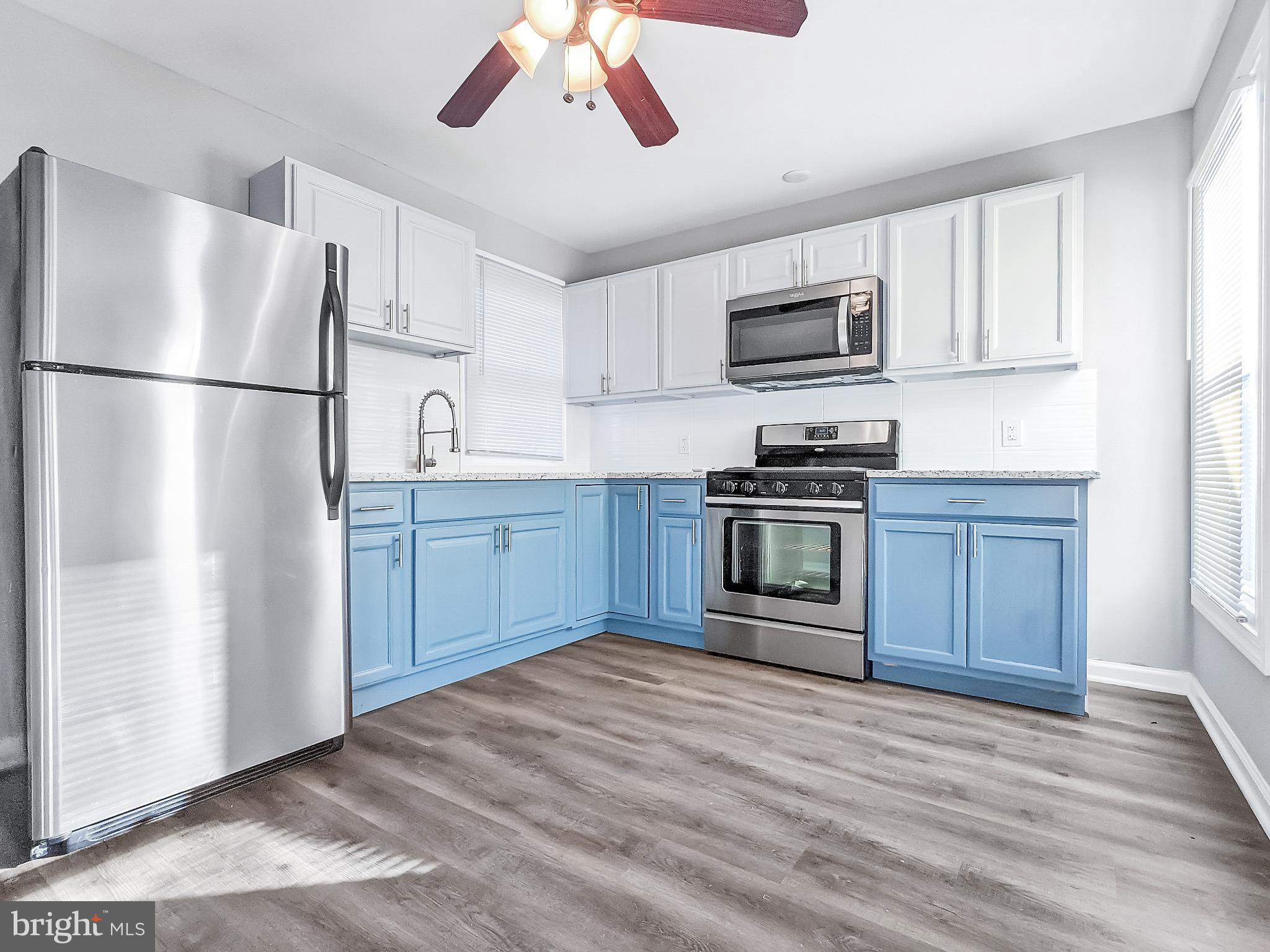 211 Main Street Dundalk, MD 21222 - Photo 5 of 22 Bright kitchen with modern blue cabinetry.