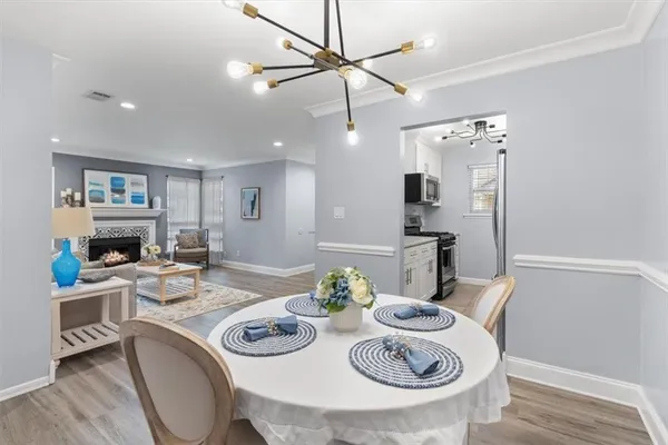 a kitchen with stainless steel appliances granite countertop a dining table and chairs