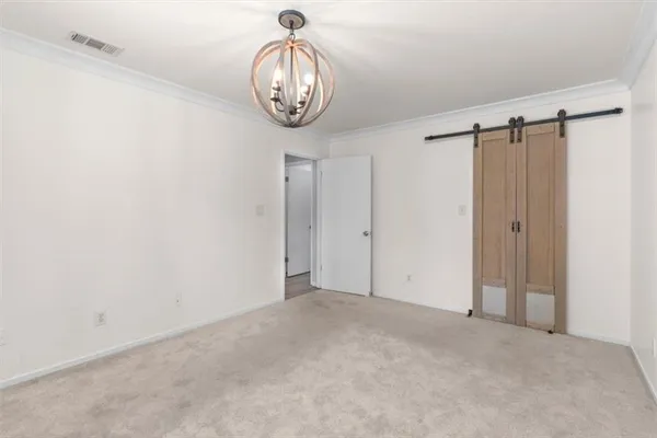 a view of an empty room with a chandelier fan