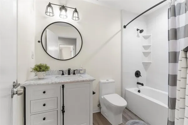 a bathroom with a granite countertop toilet sink and mirror