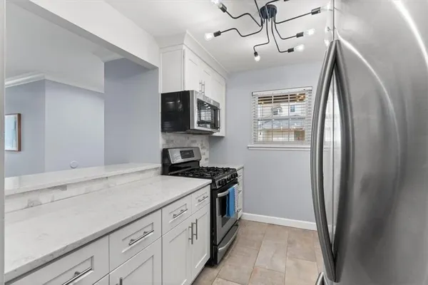 a kitchen with stainless steel appliances a refrigerator a stove a sink and a microwave