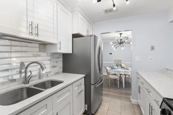 a kitchen with stainless steel appliances a sink a refrigerator and cabinets