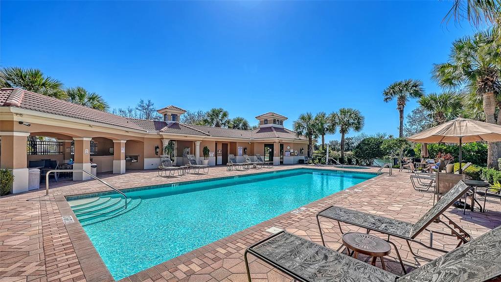 665 Crane Prairie Way Osprey, FL 34229 - Photo 55 of 61 a view of a house with pool lawn chairs under an umbrella