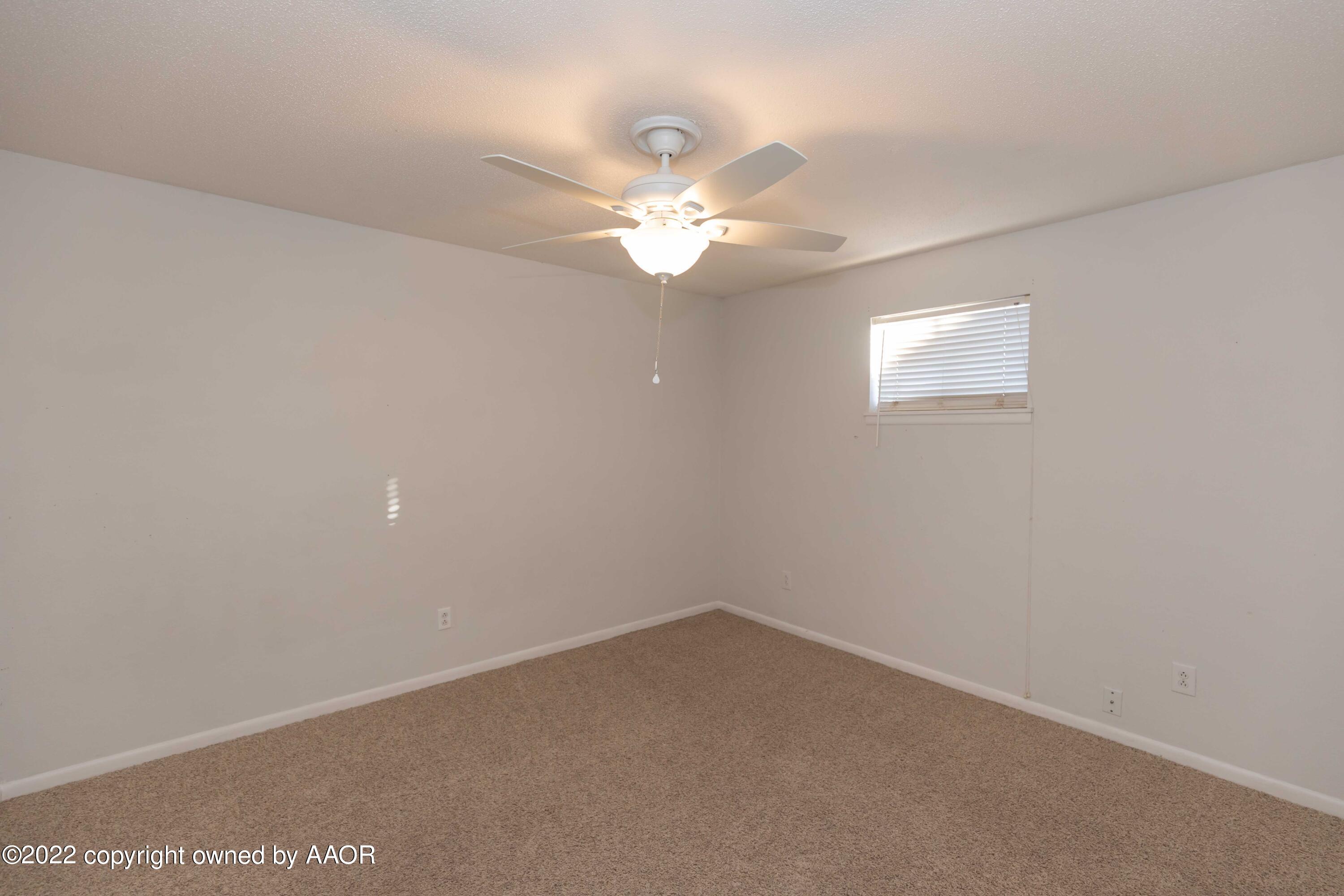 1302 Potter Street Borger, TX 79007 - Photo 26 of 53 an empty room with a window and ceiling fan