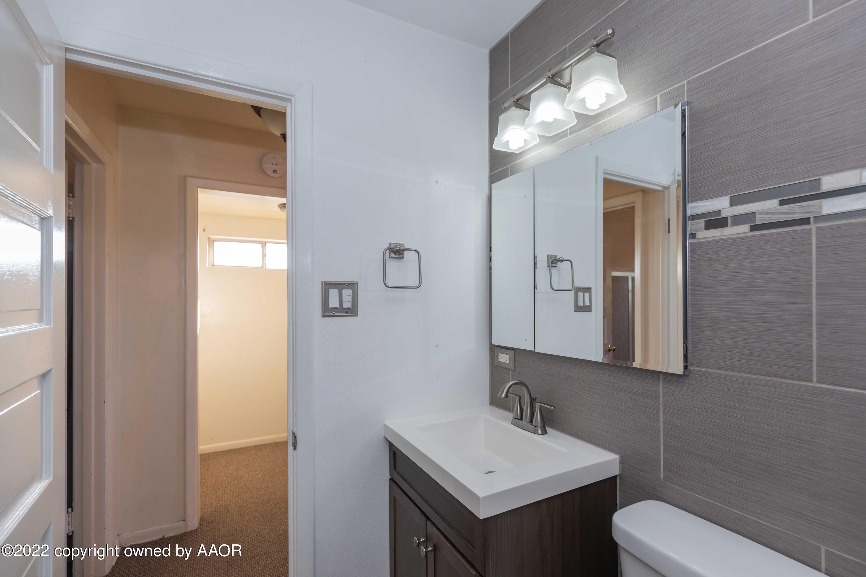 1302 Potter Street Borger, TX 79007 - Photo 32 of 53 a bathroom with a toilet sink and mirror