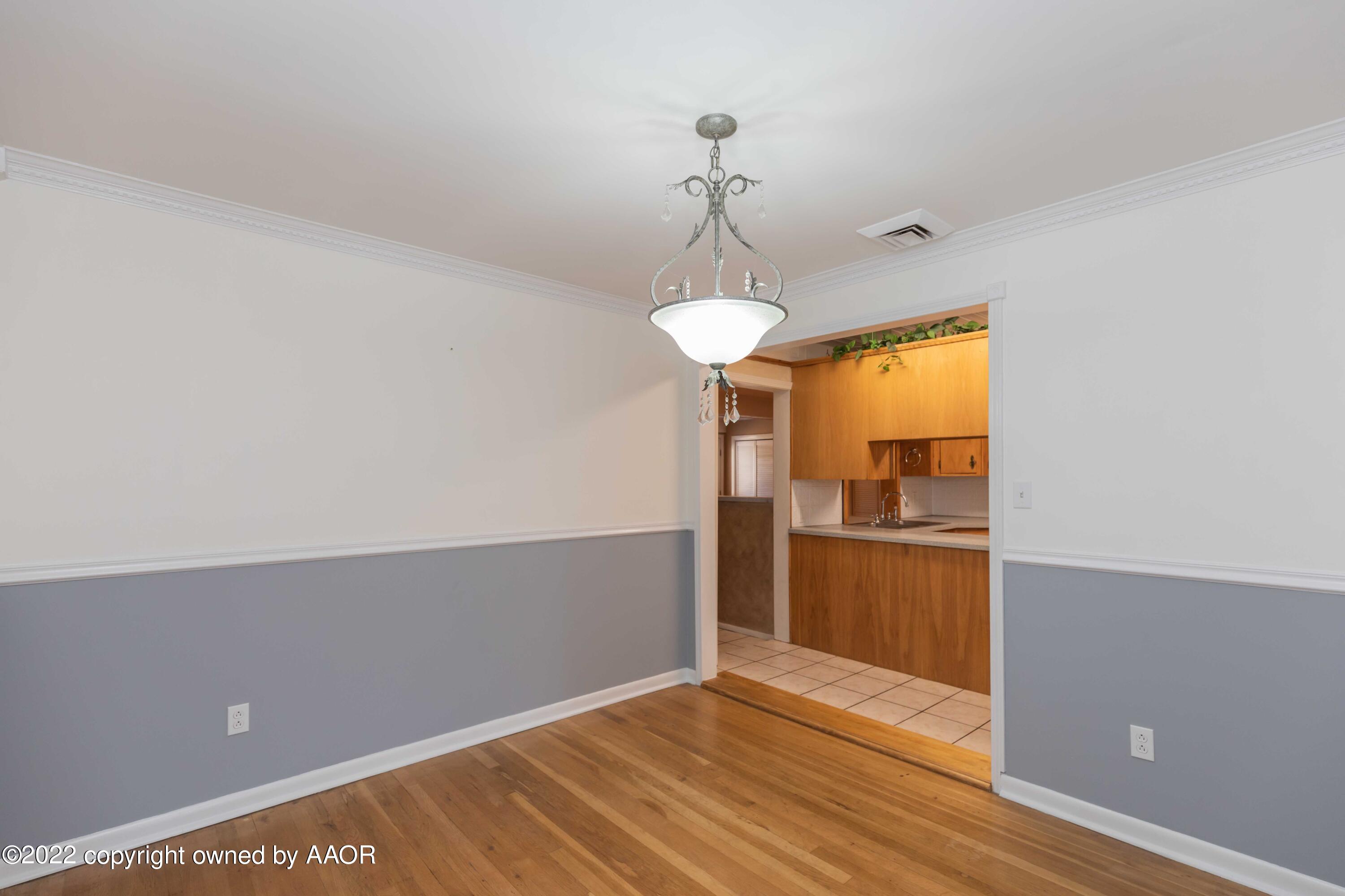 1302 Potter Street Borger, TX 79007 - Photo 9 of 53 a view of a room with wooden floor and a ceiling fan
