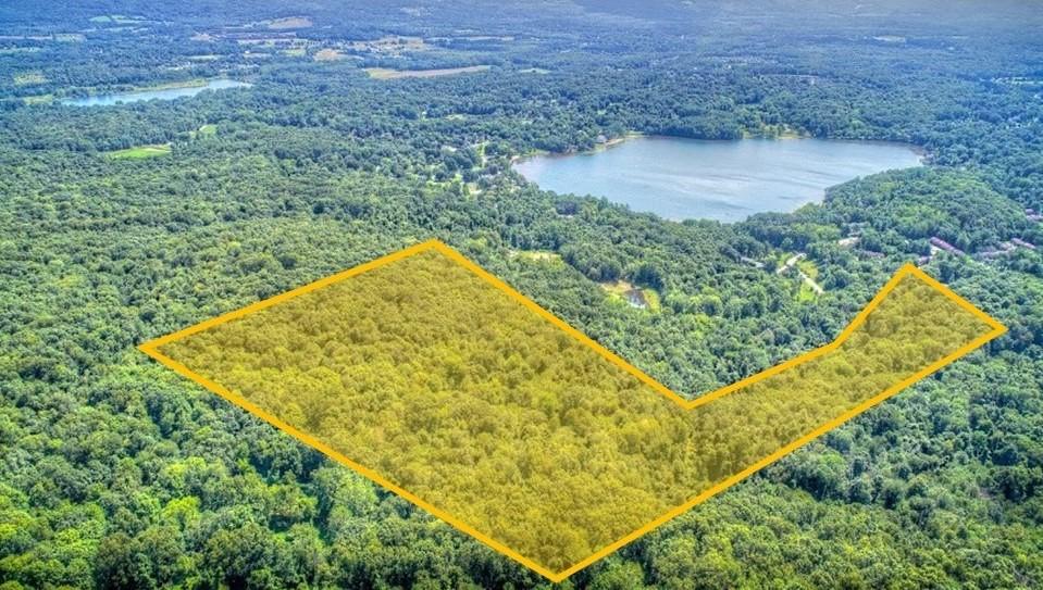 an aerial view of a house with a yard and lake view