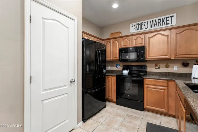 a kitchen with stainless steel appliances granite countertop a refrigerator and a stove top oven