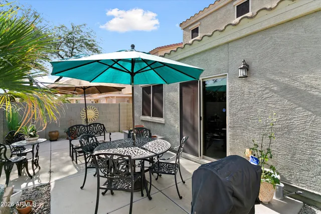 a view of a patio with furniture and a backyard