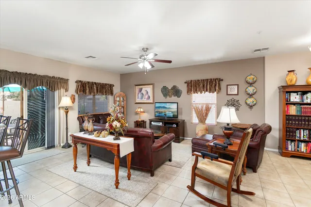 a living room with furniture a bookshelf and a window