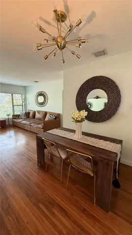 a living room with table chairs and wooden floor
