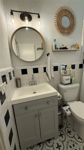 a bathroom with a toilet a sink and a mirror