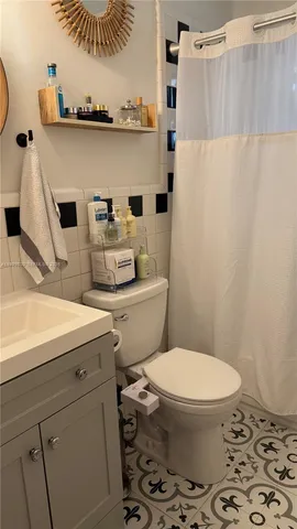 a bathroom with a sink a toilet and shower curtain