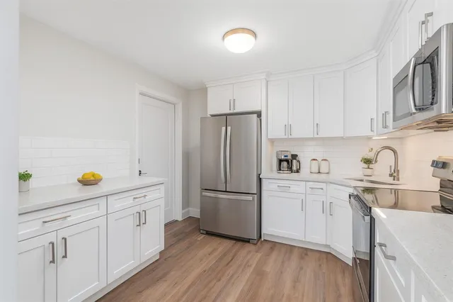 a kitchen with granite countertop white cabinets and white appliances
