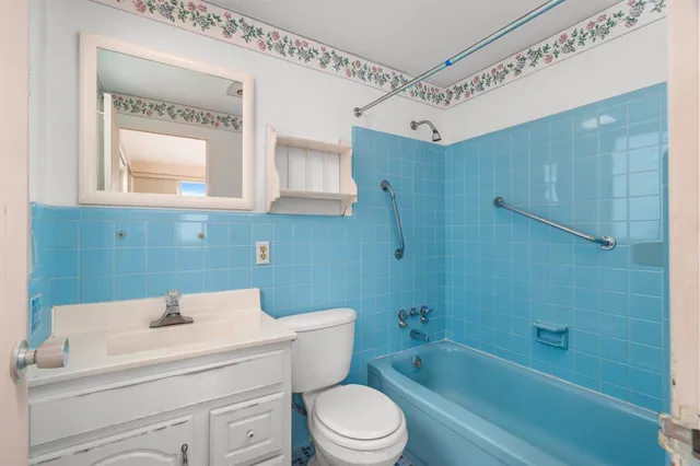 a bathroom with a sink toilet vanity and shower