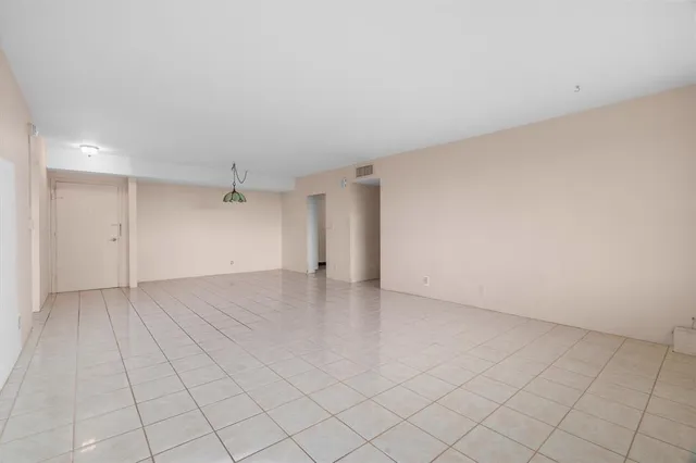 an empty room with fan and windows