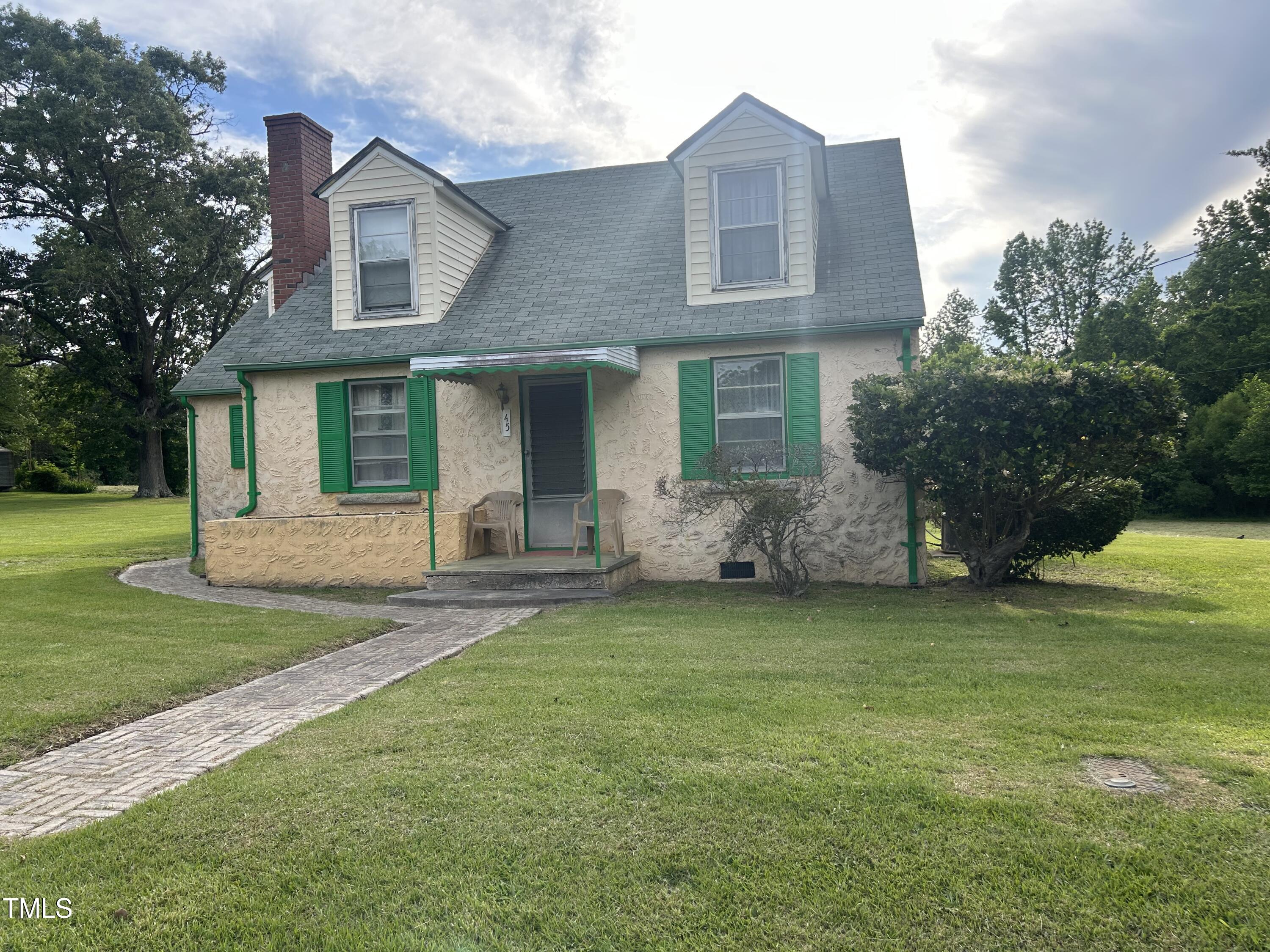 45 Perkinson Street Kittrell, NC 27544 - Photo 2 of 18 a front view of a house with a garden and trees
