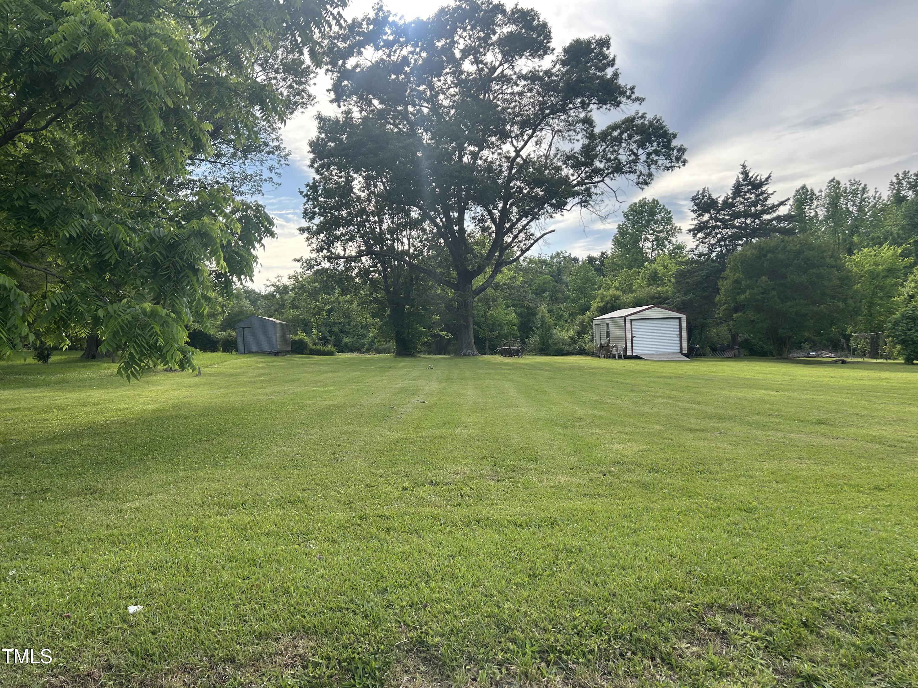 45 Perkinson Street Kittrell, NC 27544 - Photo 6 of 18 a view of a green field with trees in the background