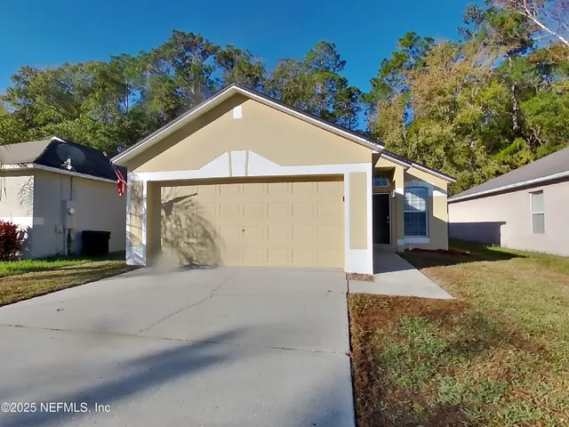 a view of a house with a yard and garage