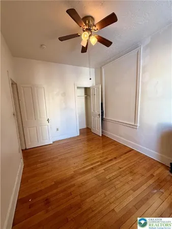 a view of an empty room and a ceiling fan