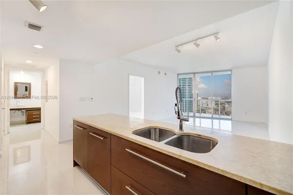 a kitchen with a sink and cabinets with wooden floor