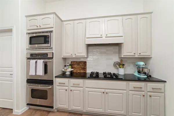 a kitchen with stainless steel appliances granite countertop a sink and refrigerator