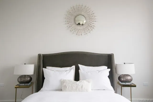 a bed in a room with a lamp and a large mirror