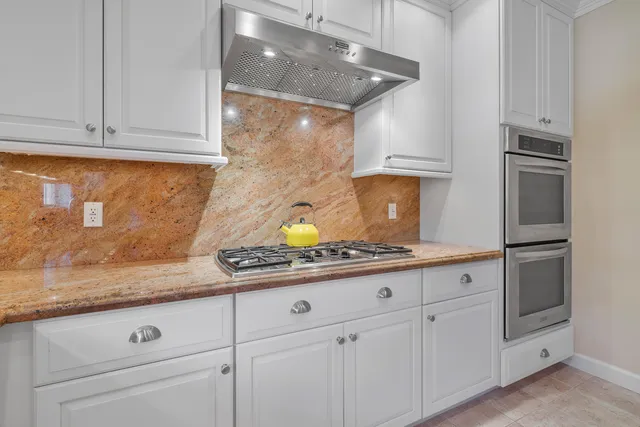 a kitchen with granite countertop white cabinets and white appliances