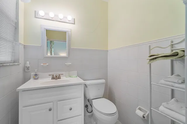 a bathroom with a toilet sink vanity and mirror