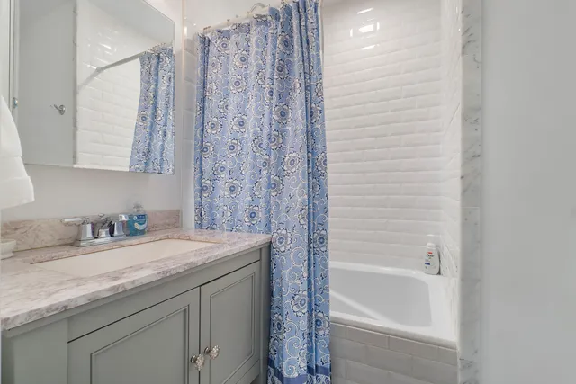 a bathroom with a granite countertop sink a toilet and bathtub
