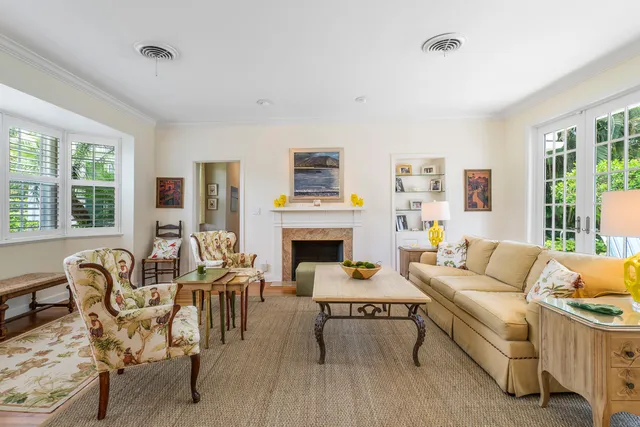 a living room with furniture a fireplace and a large window