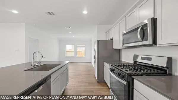 a kitchen with stainless steel appliances granite countertop a sink stove and cabinets