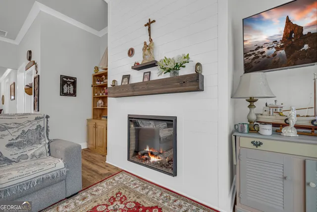 a view of a dining room and livingroom with furniture wooden floor a chandelier