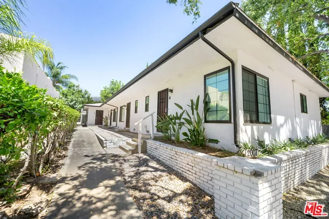a view of a house with backyard and sitting area