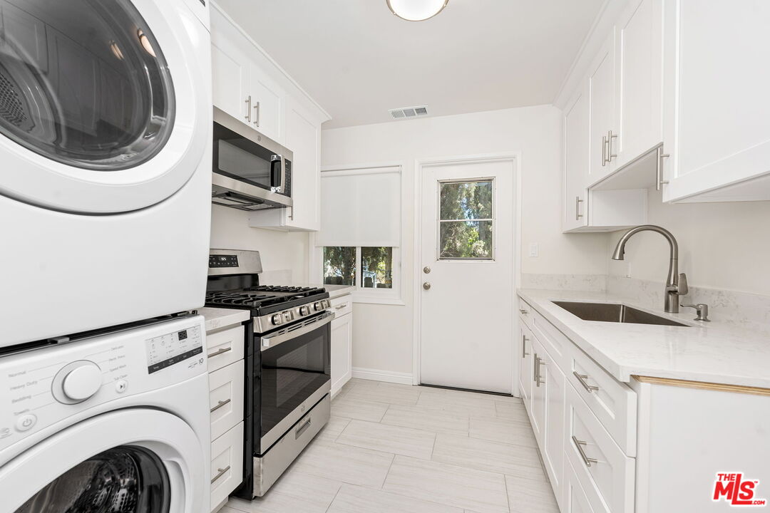 2007 East Villa Street, Unit A Pasadena, CA 91107 - Photo 9 of 12 a kitchen with stainless steel appliances granite countertop white cabinets a sink and a stove