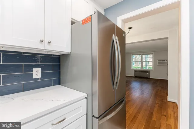 a kitchen view with wooden floor and electronic appliances