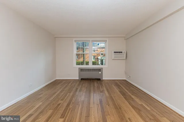 a view of a room with wooden floor and window