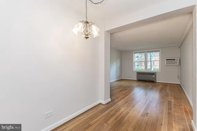 a view of empty room with wooden floor and window